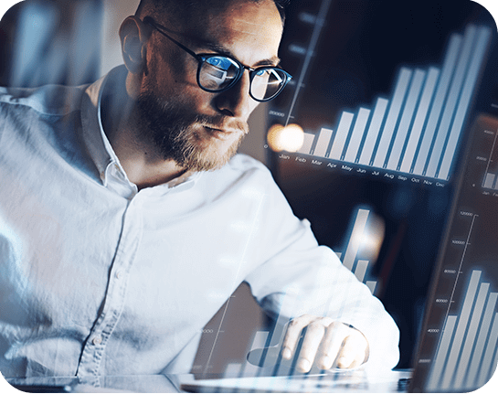 man with glasses looking at graphs